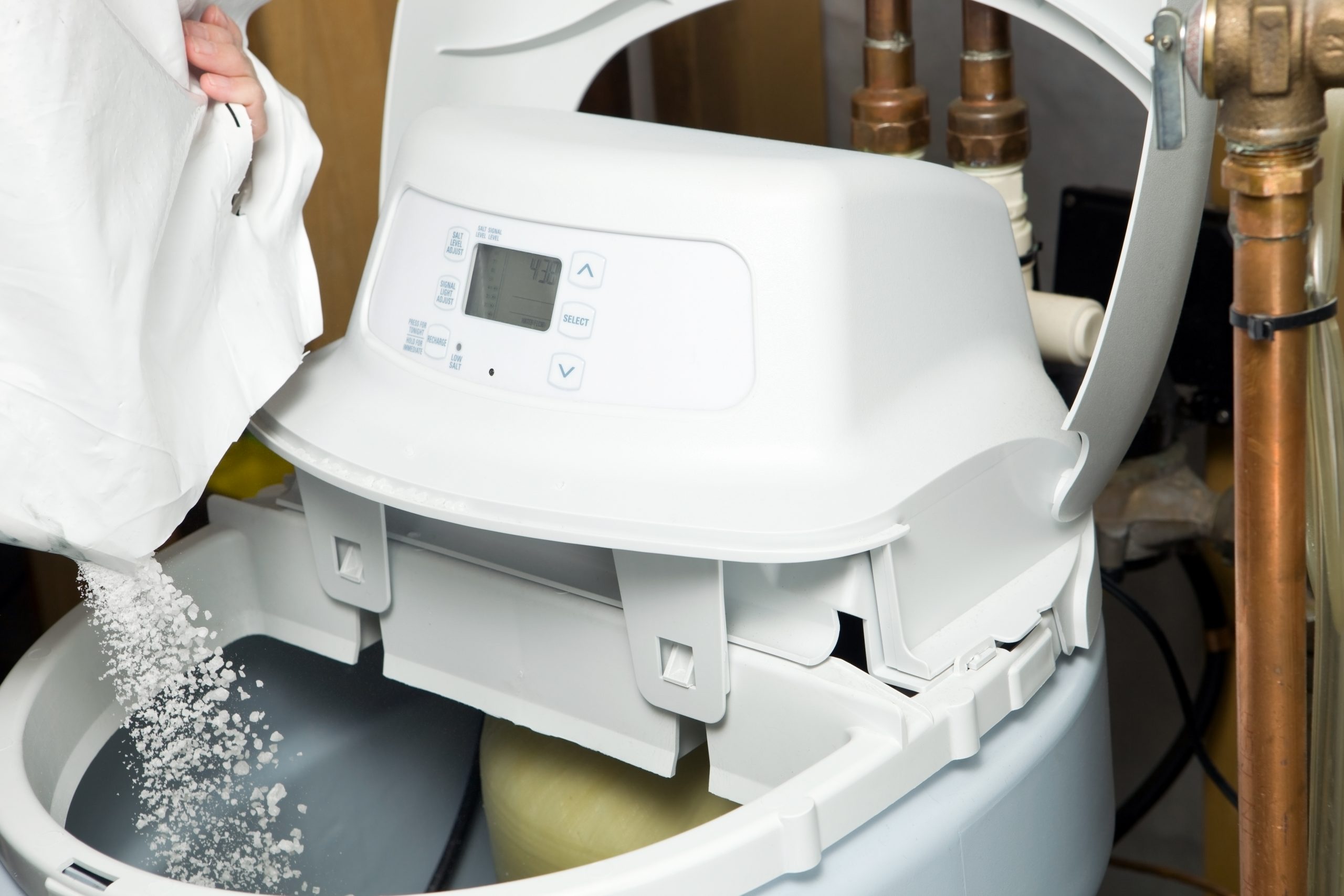 A homeowner performs water softener maintenance.