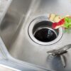 Scraps of fruit sitting in a sink before going down the garbage disposal.